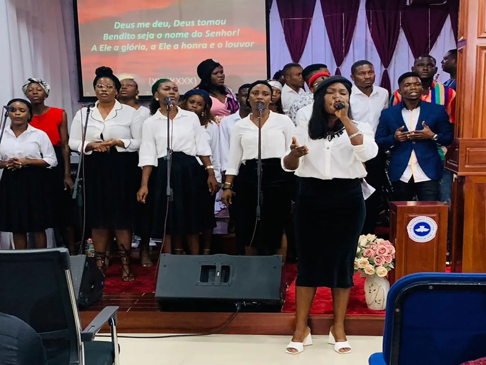 The Resurrection Ground Parish youth choir in white, singing together during Youth Weekend